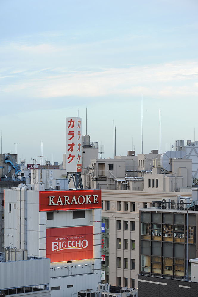 Blick über Tokio mit Hochhäusern und Leuchtreklame in der Abenddämmerung