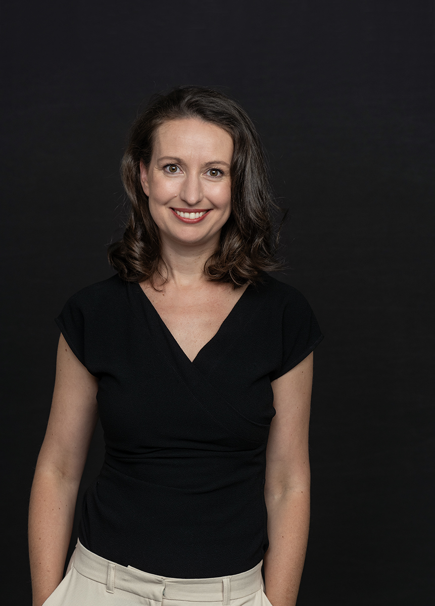 Yasmine Riechers im schwarzen Oberteil vor dunklem Hintergrund
